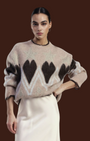 Maglione Madison Shop girocollo beige con stampa cuori e stelle, maniche lunghe e bordo ondulato, indossato da modella