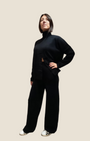 Modella indossa completo Madison Shop nero in maglia con dolcevita a apertura frontale e pantaloni a gamba ampia