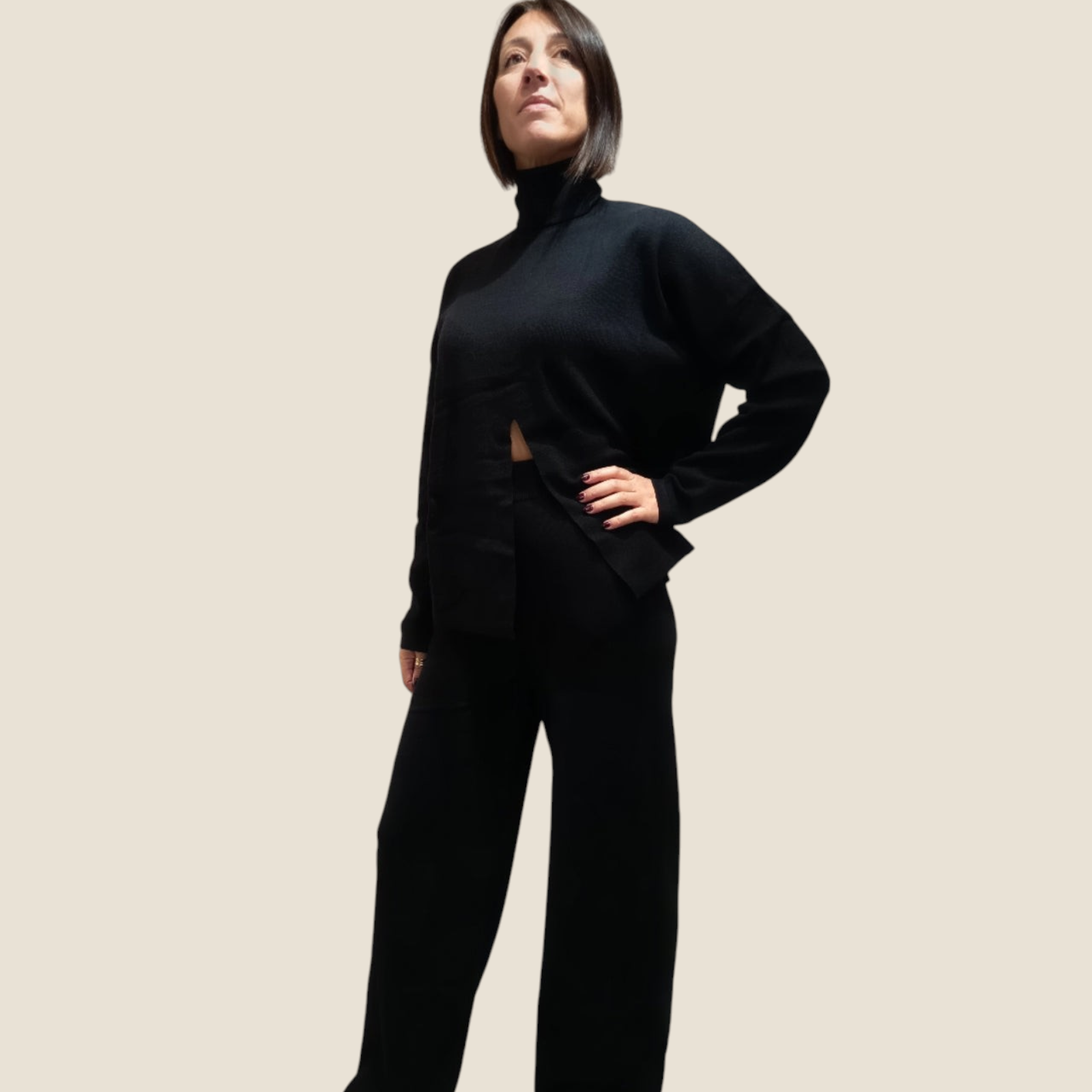 Modella indossa completo Madison Shop nero in maglia con dolcevita a apertura frontale e pantaloni a gamba ampia