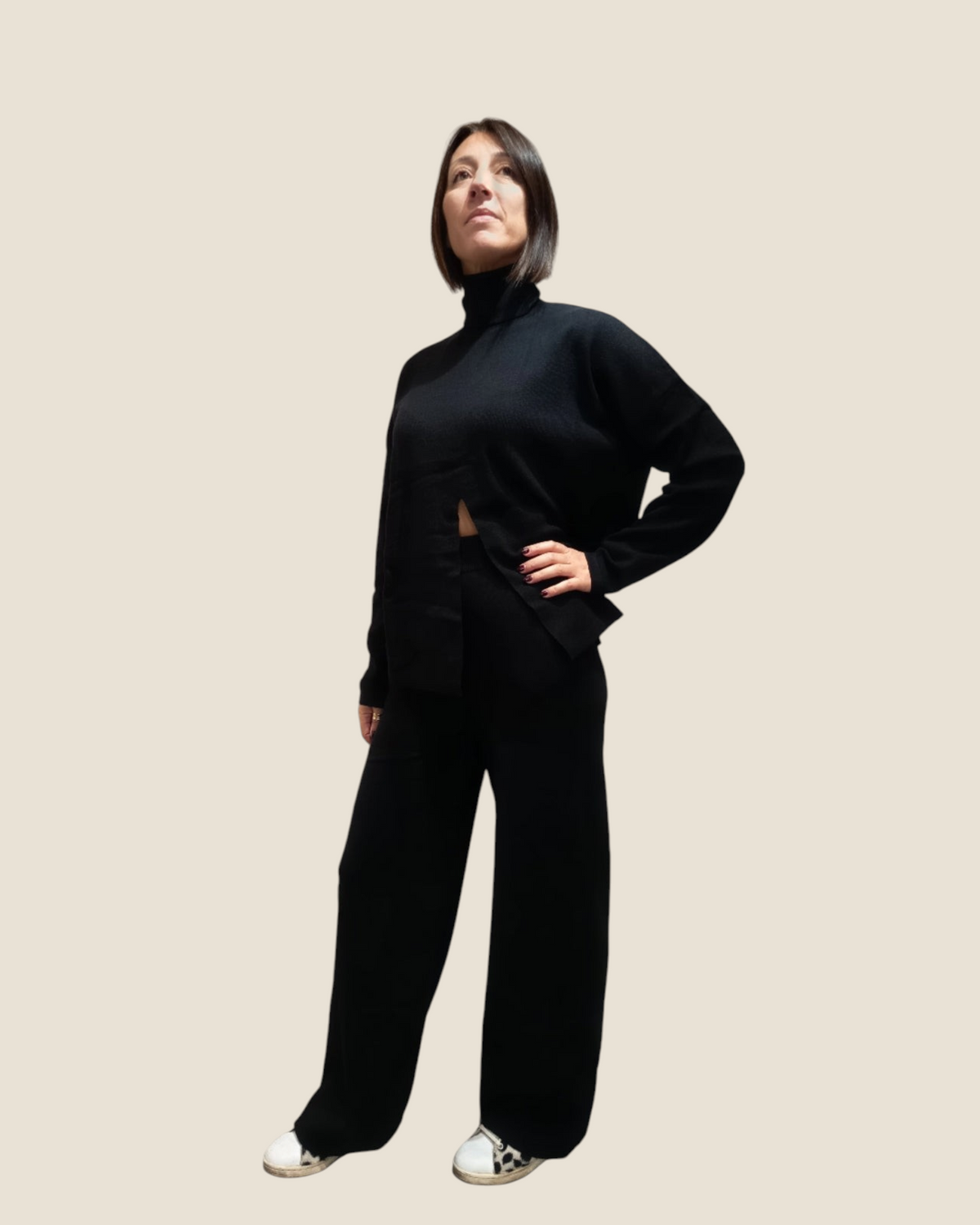 Modella indossa completo Madison Shop nero in maglia con dolcevita a apertura frontale e pantaloni a gamba ampia