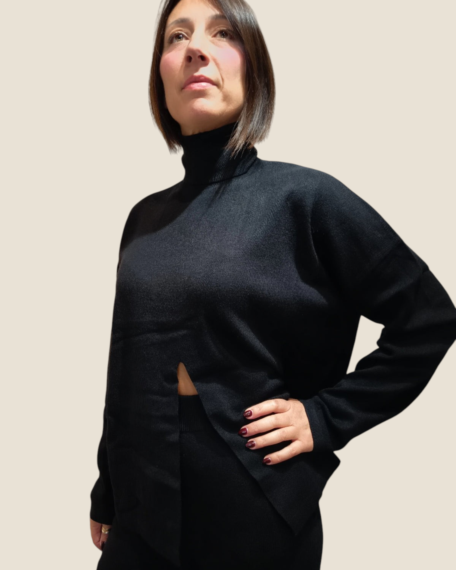 Modella indossa completo nero Madison Shop in maglia con dolcevita e apertura frontale, stile minimalista casual-chic