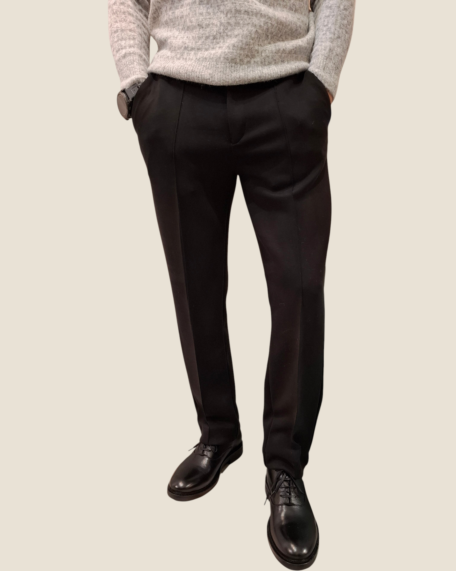 Pantaloni uomo Madison Shop slim fit neri con nervature frontali, indossati con maglione grigio e scarpe eleganti