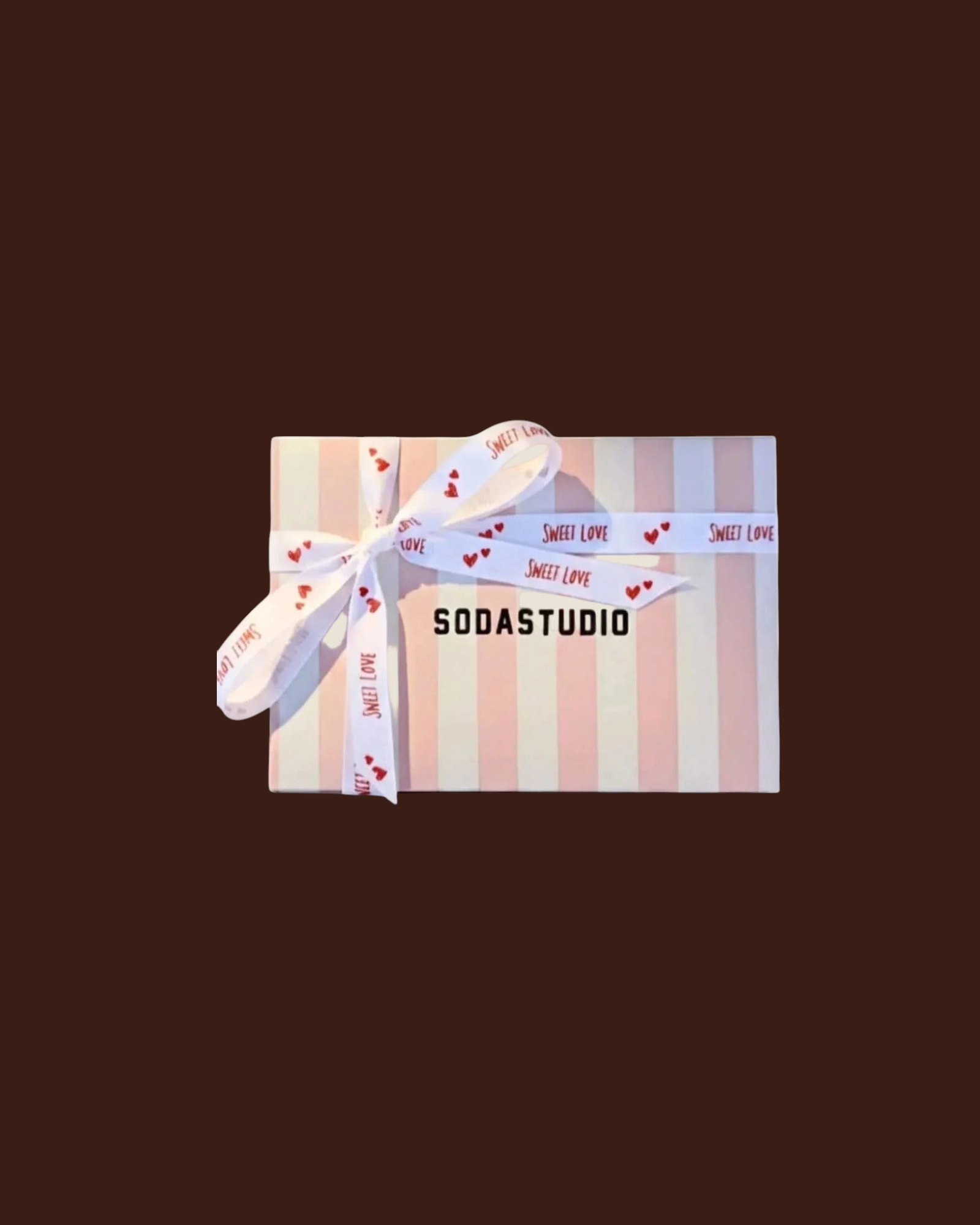Confezione regalo Madison Shop con carta a righe rosa e bianche, chiusa da un nastro bianco con cuori rossi