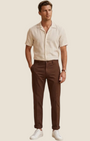 Madison Shop slim fit brown cotton chino trousers with a cuffed hem worn by a man with a beige linen shirt