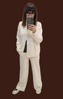 Modella indossa completo Madison Shop in maglia bianco panna con dolcevita e pantalone ampio a gamba dritta
