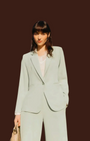 Modella indossa completo Madison Shop verde menta con giacca a un bottone e pantaloni wide-leg in tessuto fluido